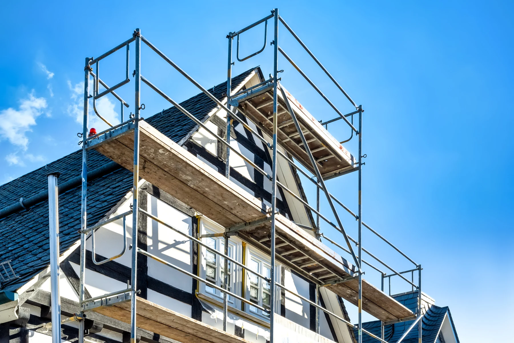 Woningrenovatie met steigers rondom de gevel en het dak